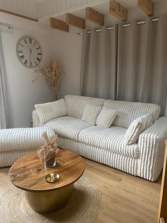 un salon avec un canapé blanc et une table dans l'établissement Maison chaleureuse, à Matemale