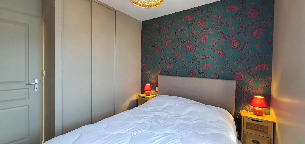 ein Schlafzimmer mit einem Bett und einer grünen Wand in der Unterkunft la perle de lecume in Quiberon