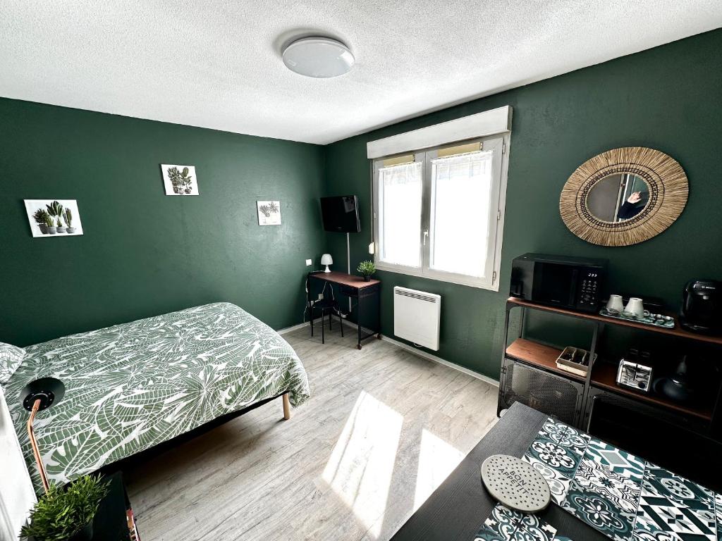 une chambre verte avec deux lits et une fenêtre dans l'établissement Studio Le république 2, à Dijon