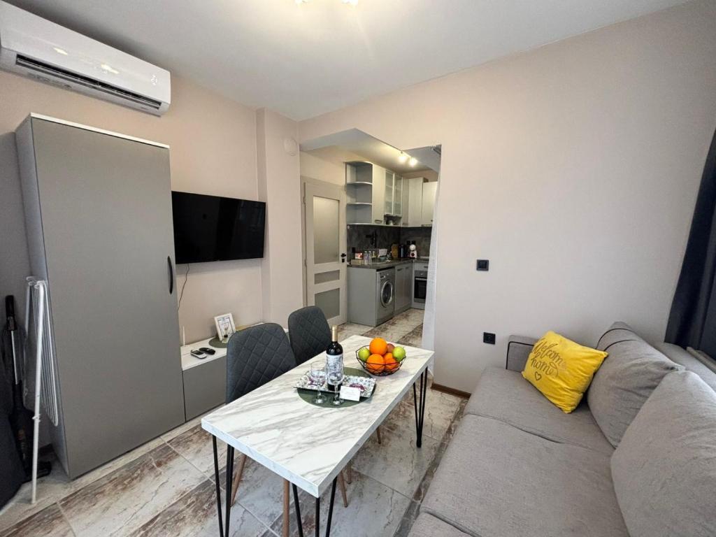 a living room with a couch and a table with fruit on it at GRAND APARTMENT OHRID - top center near to sea and sea garden in Burgas City