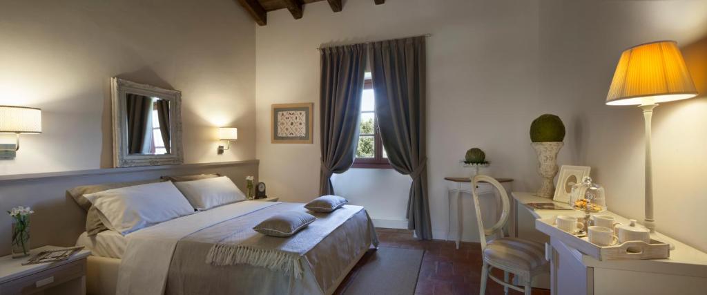 a bedroom with a bed and a desk and a lamp at Le Quattro Terre in Corte Franca