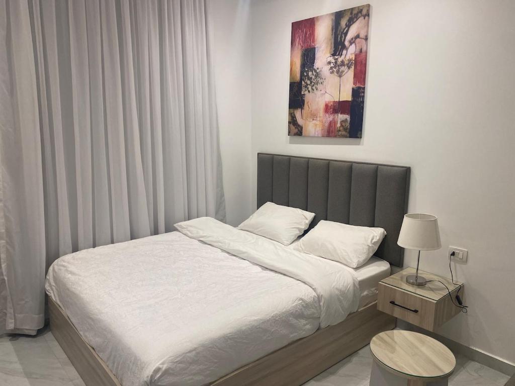 a bedroom with a bed and a table and a picture at Nile Inn 503 Cozy Studio Steps Away From the Nile in Cairo