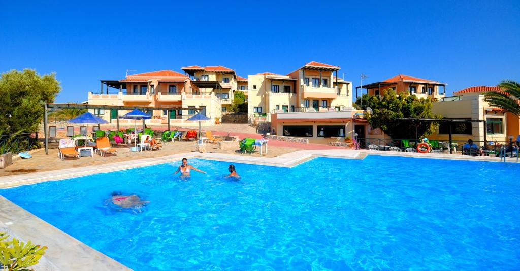 a group of people swimming in a swimming pool at Aloni Suites in Chorafakia