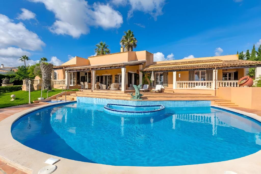 une villa avec piscine devant une maison dans l'établissement Pura Vida, à Son Servera