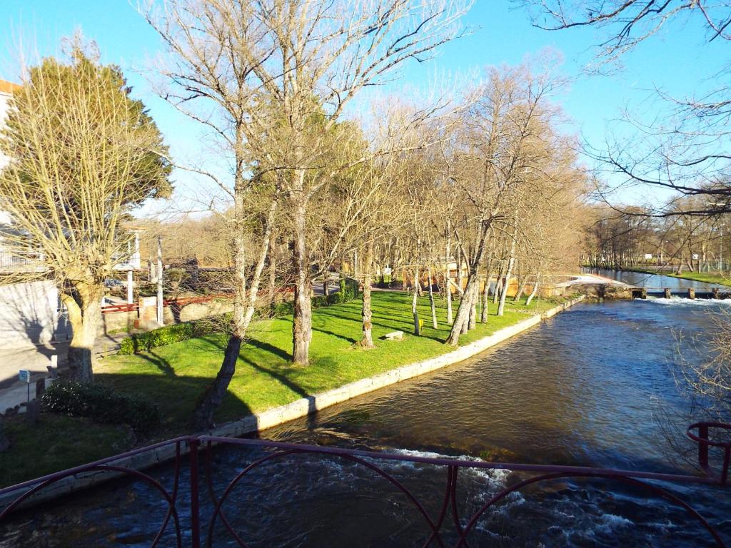 vistas a un río con árboles y un puente en Hotel Ansuiña en Baños de Molgas