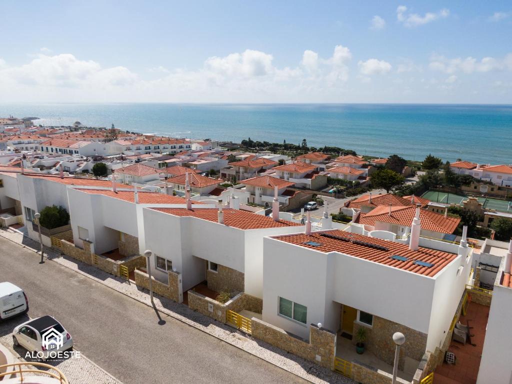 a view of a city with white buildings and the ocean at Ericeira Panoramic Sea View Apartments in Ericeira