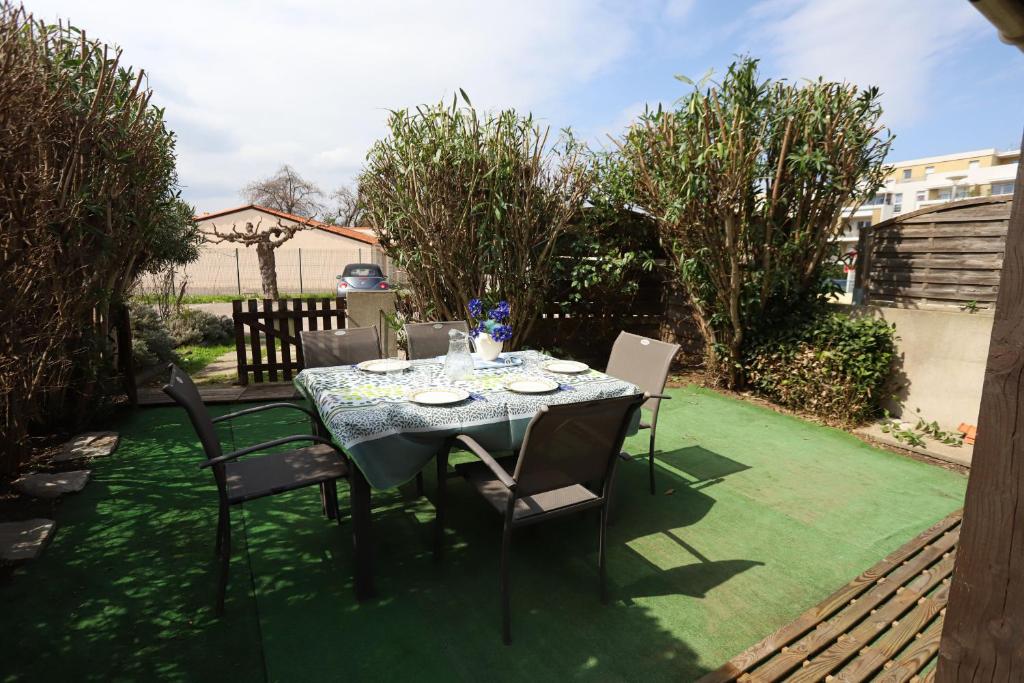 une table et des chaises assises sur une pelouse dans l'établissement Argeles sur Mer jolie maison avec terrasse et piscine, à Argelès-sur-Mer