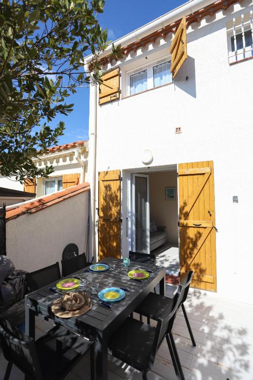 une table avec des plaques devant une maison dans l'établissement Saint Cyprien jolie maison climatisee avec une grande terrasse, à Saint-Cyprien