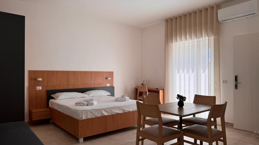 een slaapkamer met een bed, een tafel en stoelen bij Estelle in Bari