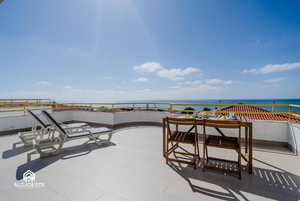 a balcony with a table and chairs and the ocean at Ericeira Panoramic Sea View Apartments in Ericeira