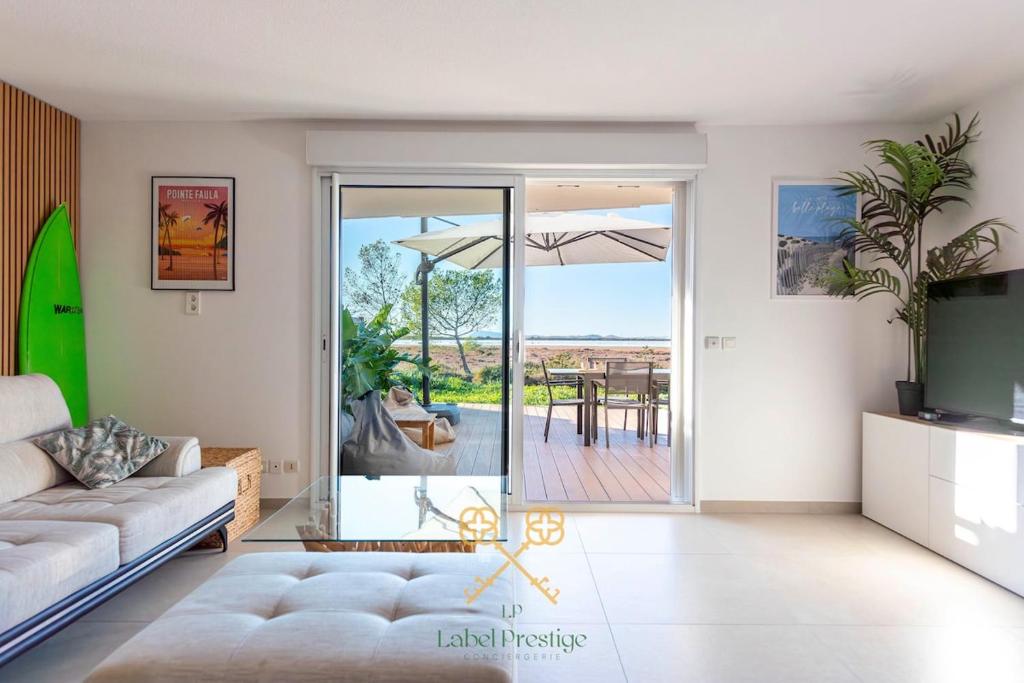 un salon avec un canapé et une porte coulissante en verre dans l'établissement Apartment la Capte, à Hyères
