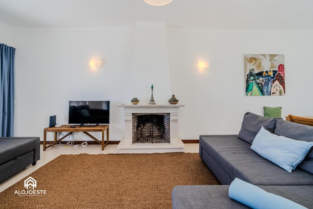 a living room with a couch and a fireplace at Ericeira Panoramic Sea View Apartments in Ericeira