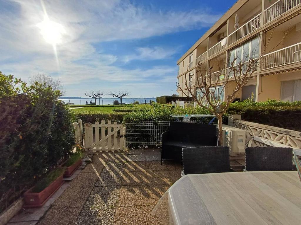 une table et des chaises devant un bâtiment dans l'établissement T1 cosy à Balaruc-les-Bains avec clim, terrasse et animaux admis - FR-1-571-59, à Balaruc-les-Bains