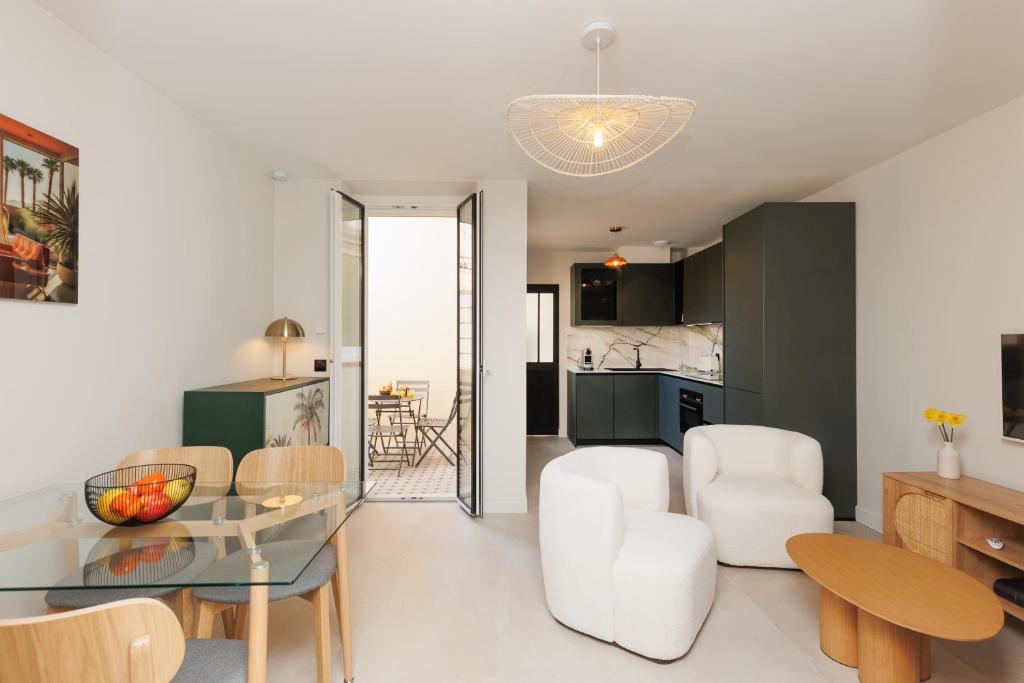 Il comprend un salon et une cuisine avec une table en verre. dans l'établissement Sublime appartement Forville Festival, à Cannes
