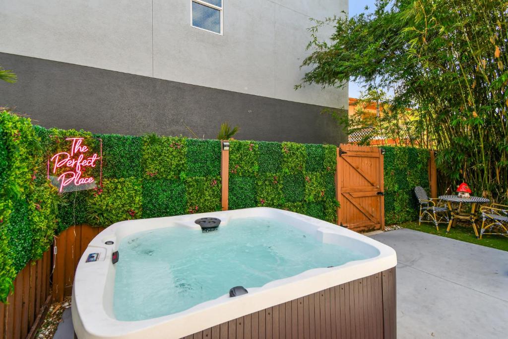 a jacuzzi tub in a yard next to a fence at Designer Sun Filled Condo - Walk to Town in St Petersburg