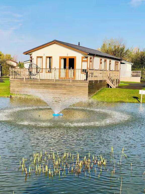 a fountain in the water in front of a house at Waterside Retreat in Wisbech