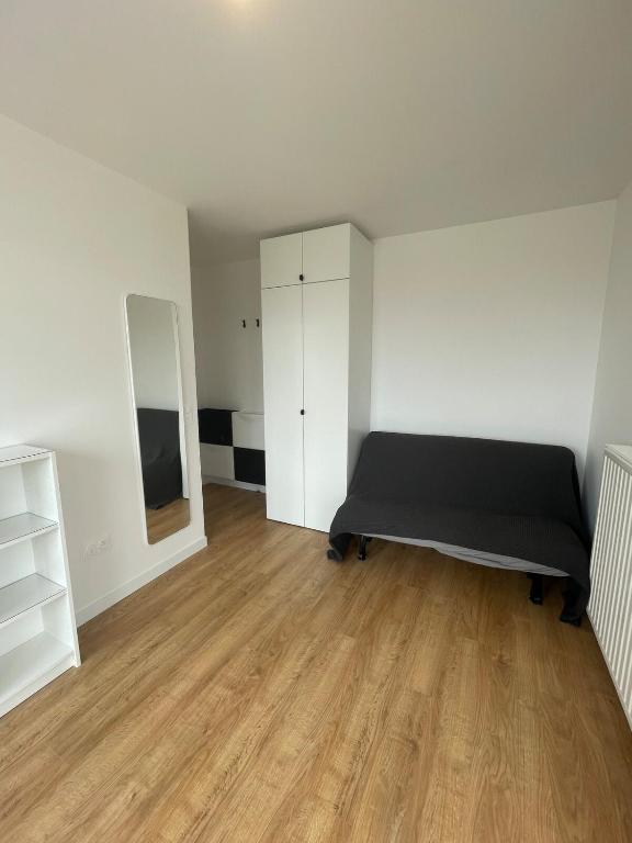 une chambre vide avec un lit et un placard dans l'établissement Studio panoramic view -Stade de France- Montmartre, à Saint-Denis