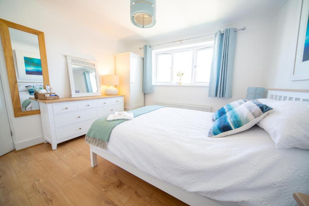 ein Schlafzimmer mit einem Bett, einer Kommode und einem Spiegel in der Unterkunft Trethvor House FREE PARKING, Ensuite Double Quiet residential area in Padstow