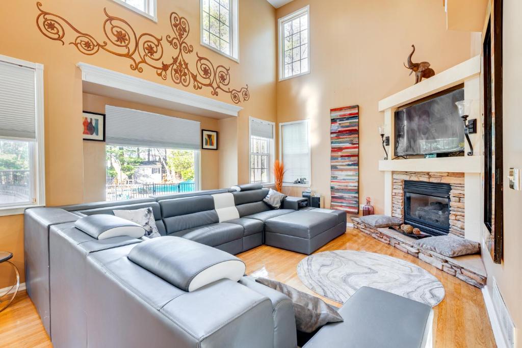 sala de estar con sofá gris y chimenea en Theater and Game Room at Trenton Area Home, en Edgewood Park