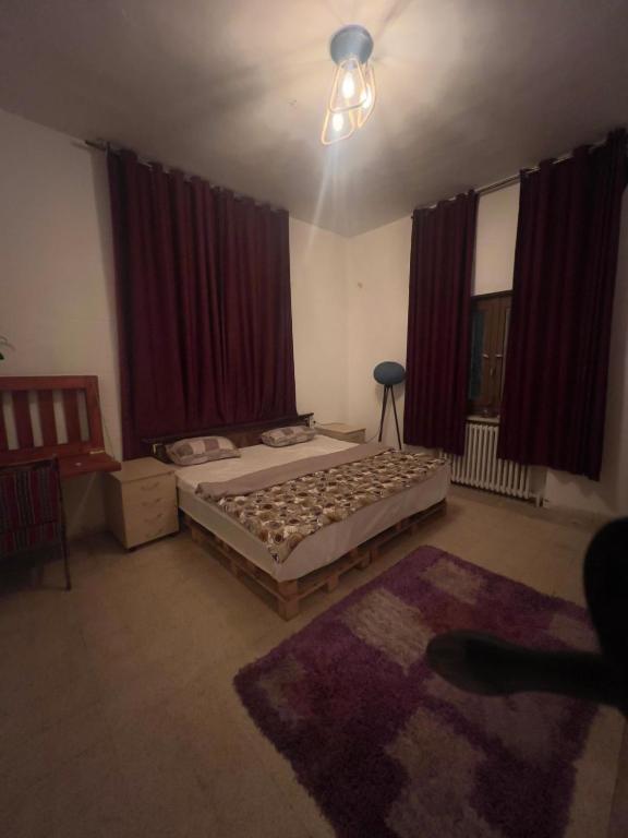 a bedroom with a bed and red curtains at bayt alrahaal in Amman