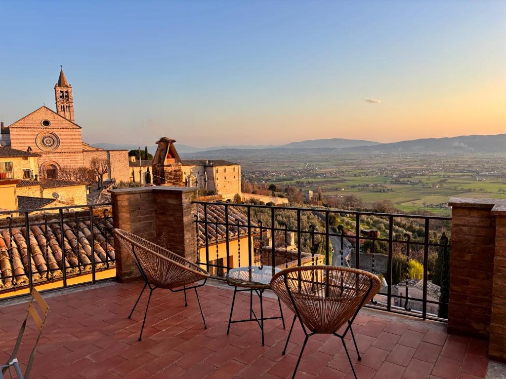 a balcony with chairs and a view of a city at CharmandView Assisi in Assisi