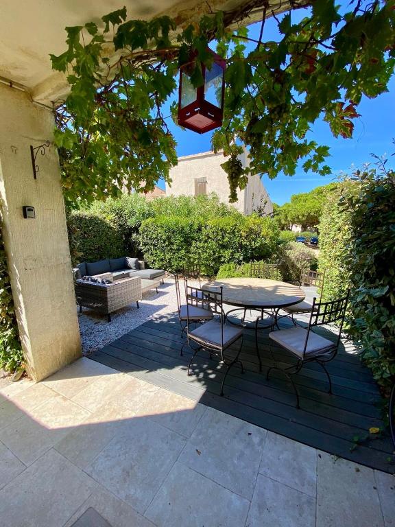 un patio avec une table et des chaises sous un arbre dans l'établissement T2 direct sea access with garden, à Calvi
