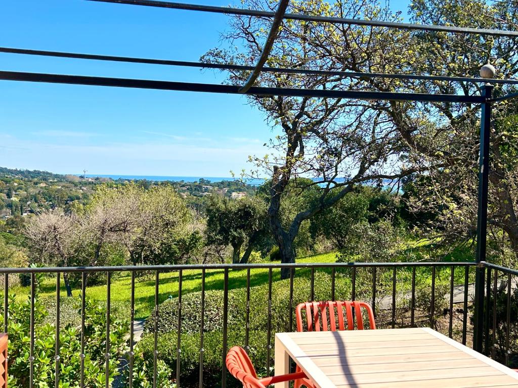 une table et des chaises sur un balcon avec vue dans l'établissement Les Restanques IRIS 2124, à Grimaud