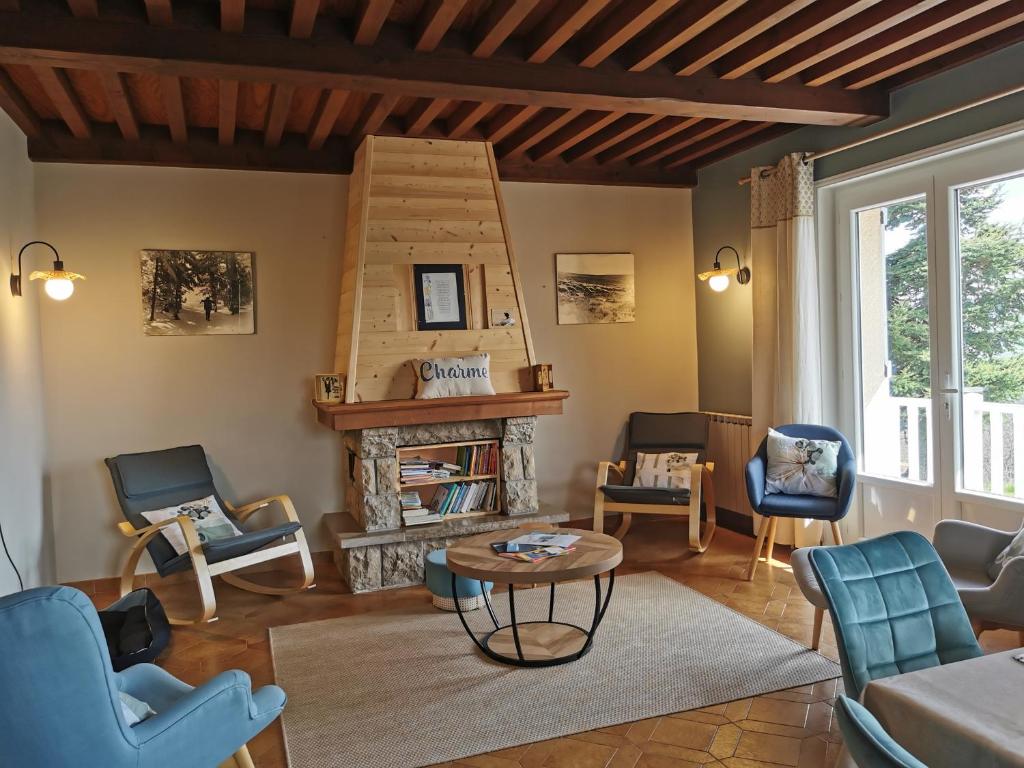 - un salon avec une cheminée et des chaises bleues dans l'établissement Le Temps des Cerises, à Saint-Georges-en-Couzan