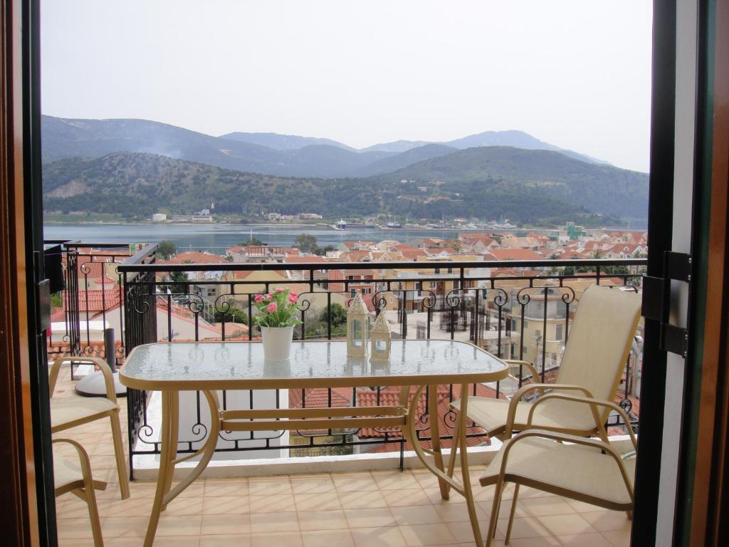 una mesa y sillas en un balcón con vistas en Barbara΄s Apartments, en Argostoli