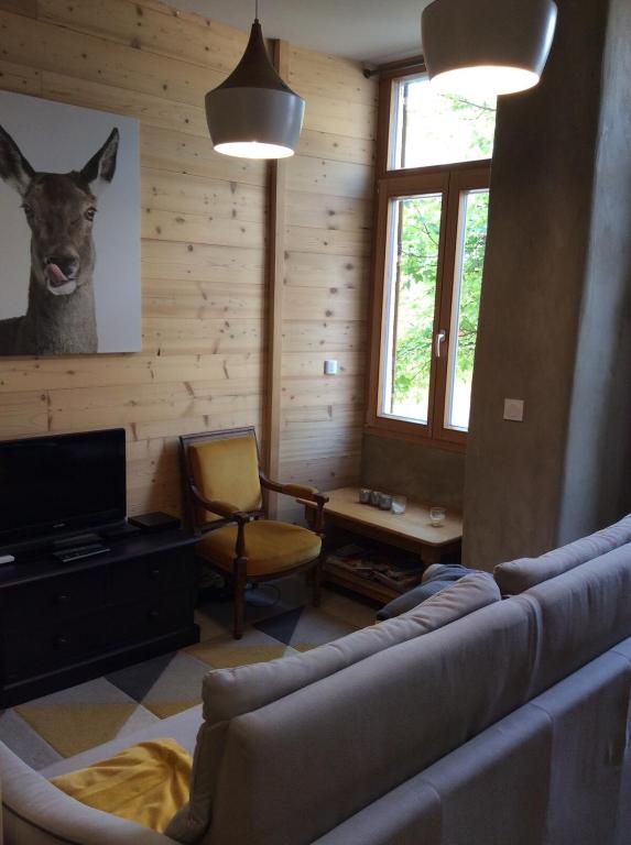 - un salon avec un canapé et une tête de cerf sur le mur dans l'établissement Huez village beautiful apartment, à Huez