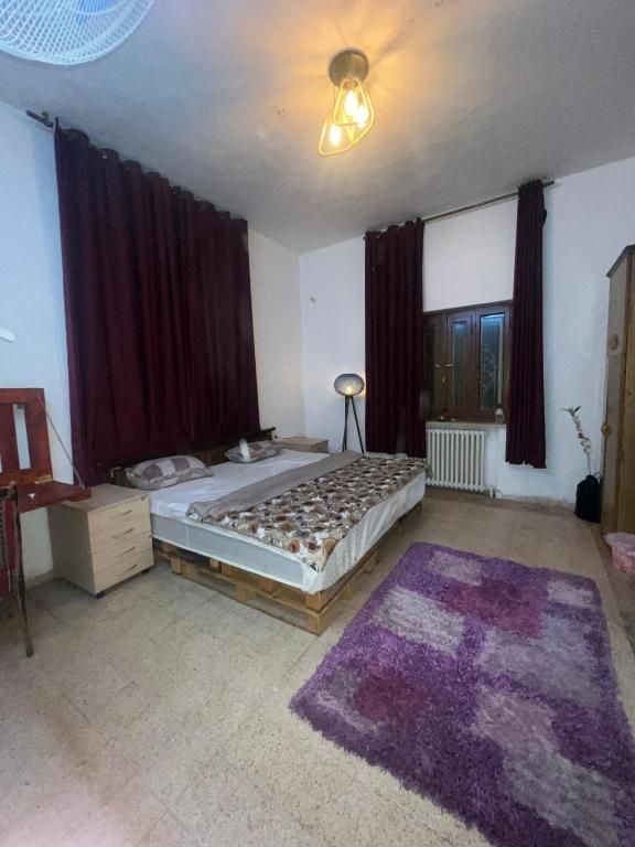 a bedroom with a bed and a large window at bayt alrahaal in Amman