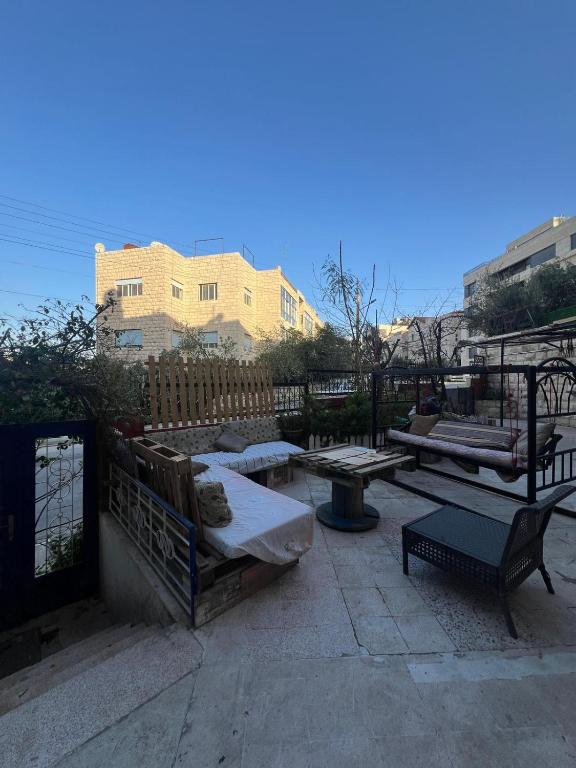 a patio with benches and tables and a fence at bayt alrahaal in Amman