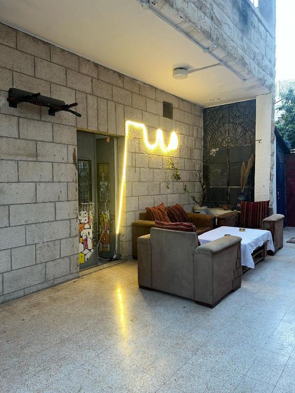 a room with a bed and couches on a brick wall at bayt alrahaal in Amman