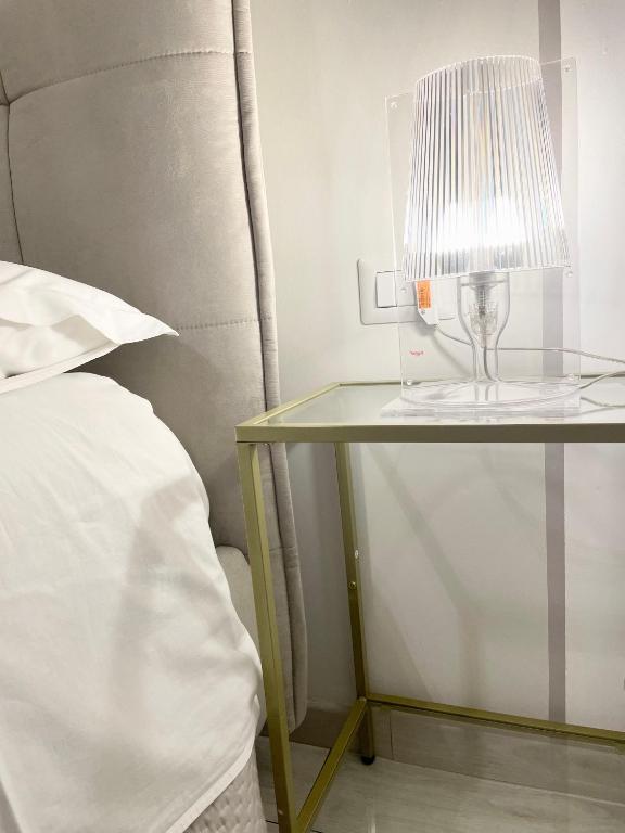 stół z lampką obok łóżka w obiekcie Salerno Center House - Corso Vittorio Emanuele w mieście Salerno
