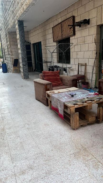 a wooden table sitting in front of a building at bayt alrahaal in Amman
