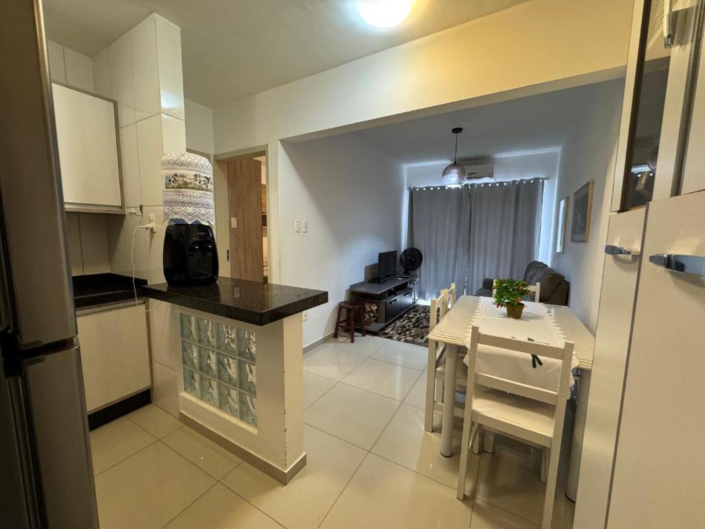 a kitchen and dining room with a table and a kitchen and a room at Apartamento 01 quarto 5min da Praia Baln Camboriu in Balneário Camboriú