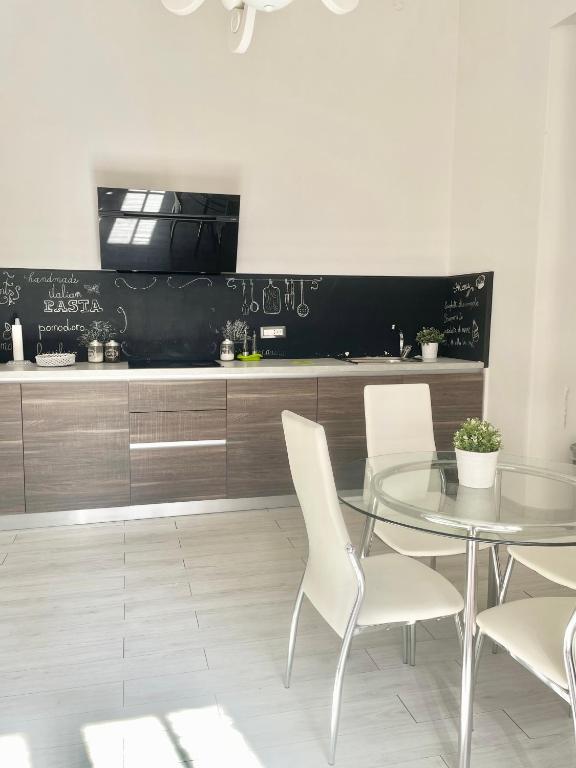 jadalnia ze szklanym stołem i białymi krzesłami w obiekcie Salerno Center House - Corso Vittorio Emanuele w mieście Salerno