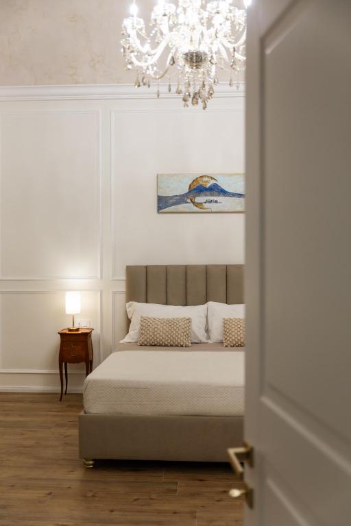 a bedroom with a bed and a chandelier at Angiolina Suite in Naples