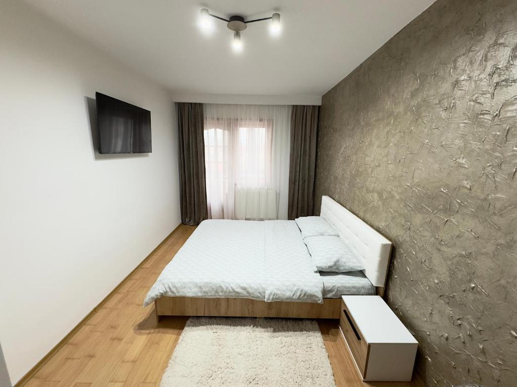 una camera da letto con un letto e una parete di Rusky Apartment a Gura Humorului