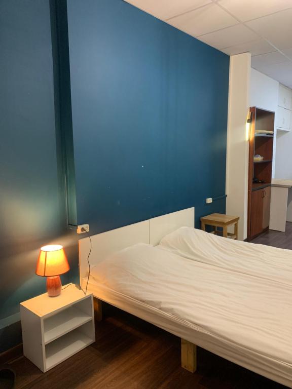 a bedroom with a white bed and a blue wall at Family Hostel and Tours in Yerevan
