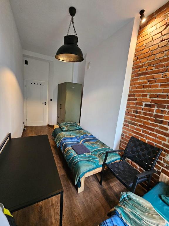 a room with a bed and a brick wall at 7Wygodny pokoj w centrum Wroclawia in Wrocław