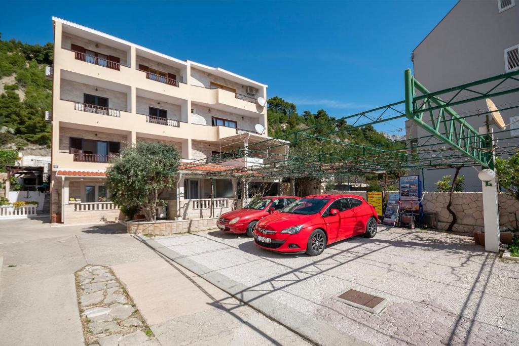 two cars parked in a parking lot in front of a building at Apartment Karlo in Duće