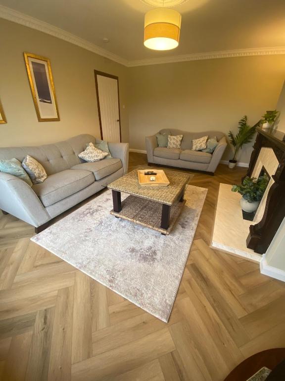 a living room with a couch and a coffee table at Woodview Cottage in Mill Loughan