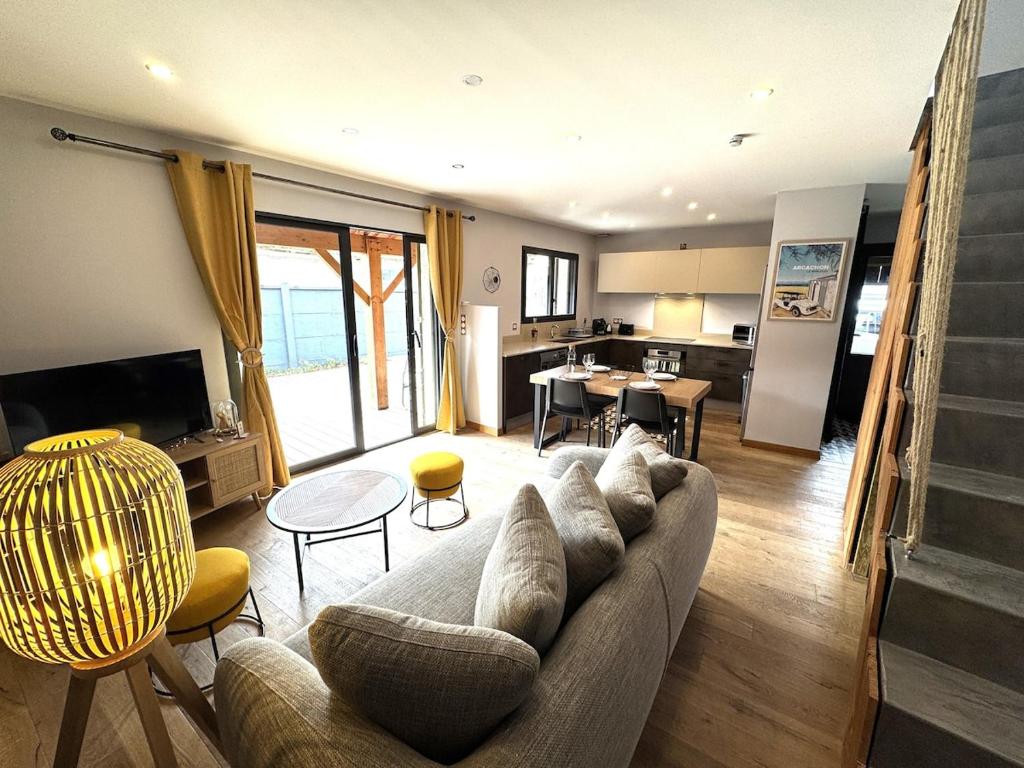 un salon avec un canapé et une table dans l'établissement Havre du Bassin avec piscine et studio indépendant, à Gujan-Mestras