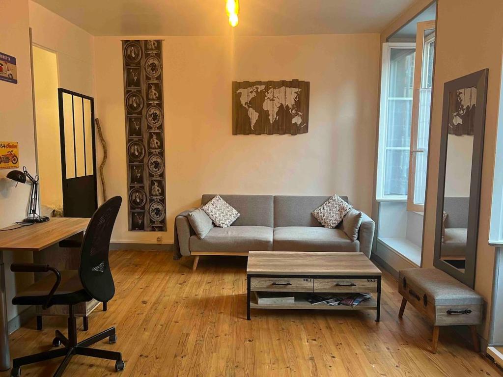 un salon avec un canapé et une table dans l'établissement T1 loft spirit, à Clermont-Ferrand