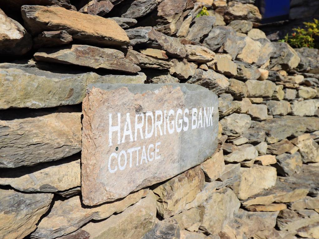 a stone sign on the side of a rock wall at Hardriggs Bank Cottage in Kendal