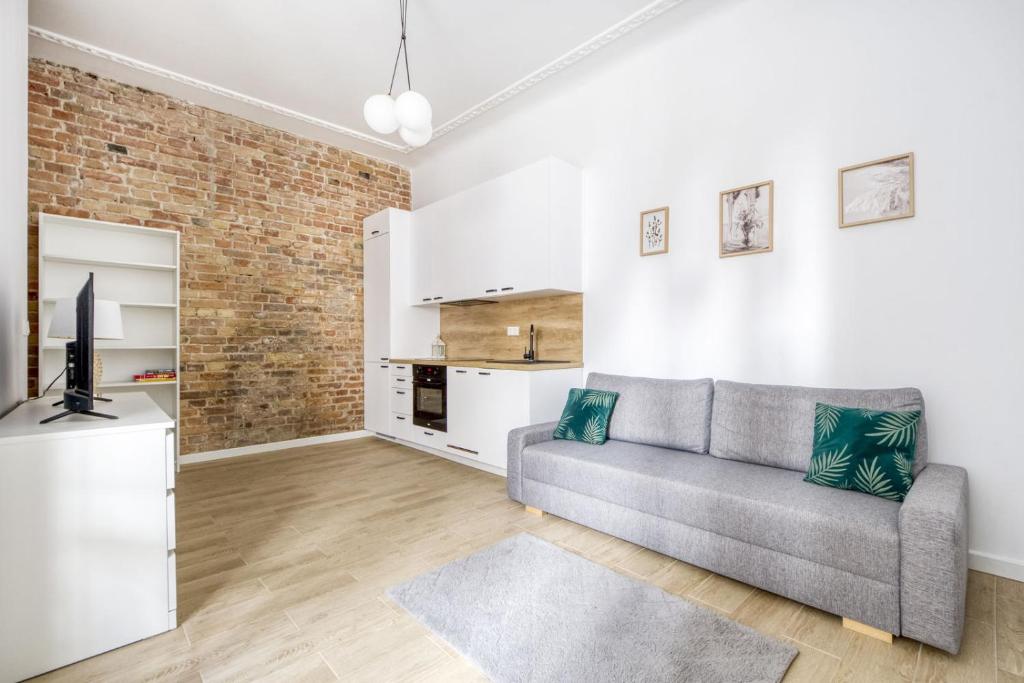 a living room with a couch and a brick wall at Apartament Centrum in Warsaw