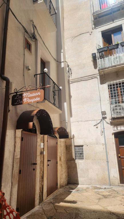 a building with a wooden door and a balcony at La Maison De Poupée in Bari