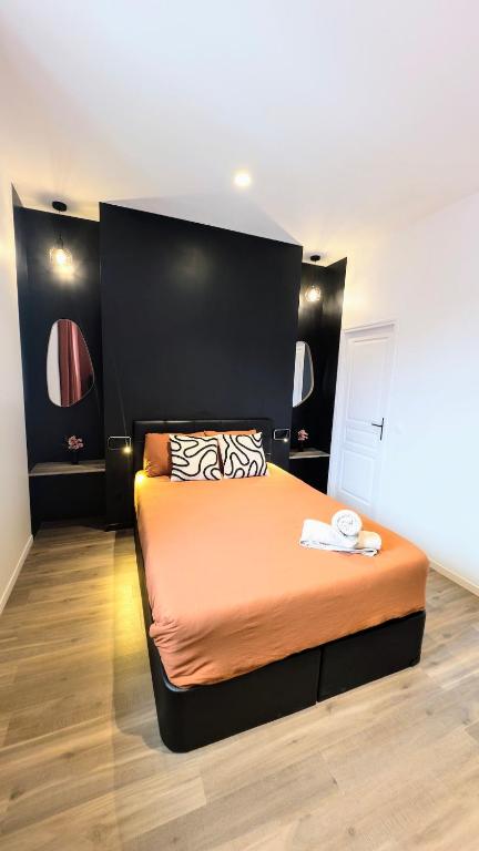 une chambre avec un grand lit avec une grande tête de lit dans l'établissement Le caviste 2ème Étage, à Abbeville