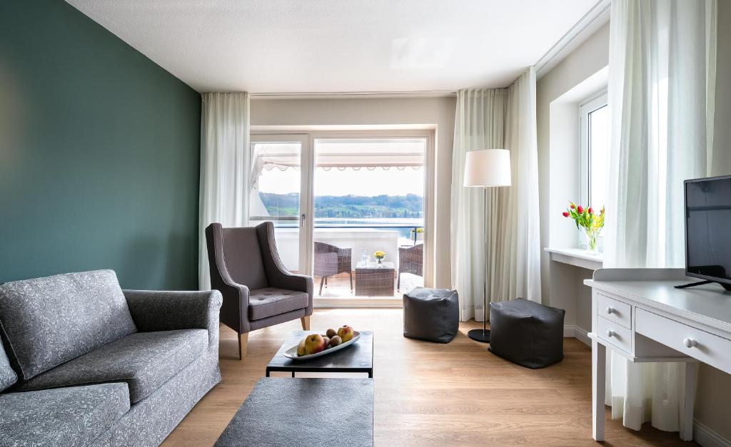 a living room with a couch and a television at Residenz Seeterrasse Restaurant & Hotel in Wangen